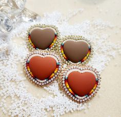 three heart shaped earrings sitting on top of a table