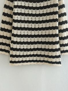 a black and white striped sweater hanging on a wall