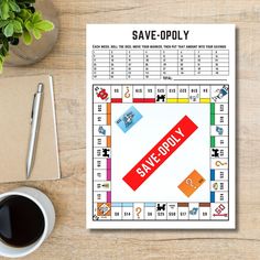 a game board with the words save - opoly on it next to a cup of coffee