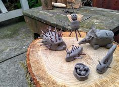 some very cute little toy animals on top of a piece of wood with holes in the middle