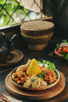 a plate full of food sitting on top of a table next to a tea pot