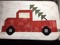 a red truck with a christmas tree on it's back sitting on top of a table