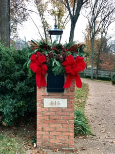 a brick mailbox decorated with poinsettis and pine cones