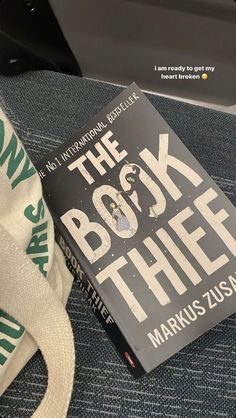 the book thief by markus zuss is sitting next to a bag