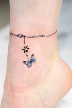 a small tattoo on the ankle of a woman's foot with a blue butterfly