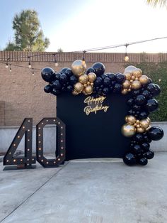 a black and gold balloon arch with the number forty on it