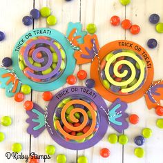 three paper plates with candy candies in the shape of spirals and words trick or treat on them