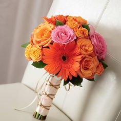 an orange and pink bouquet on a white chair