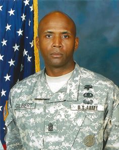 a man in uniform standing next to an american flag