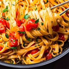 a pan full of pasta with tomatoes and parsley