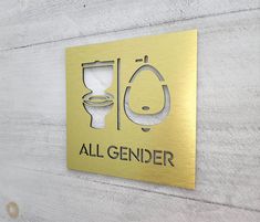 a sign that says all genderer with a toilet and sink in the center on a wooden wall