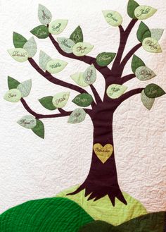 a tree with leaves and a heart on it is in the middle of a quilt