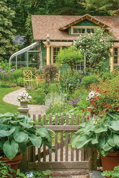 a wooden bench sitting in front of a lush green house