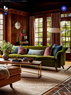 a living room filled with lots of furniture next to large windows and wooden paneled walls