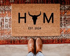 a person standing in front of a door mat with the word h m on it