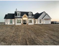 a large white house sitting on top of a dry grass field