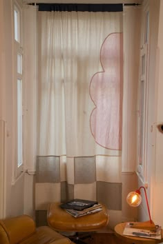 a chair and table in front of a window with a book on top of it