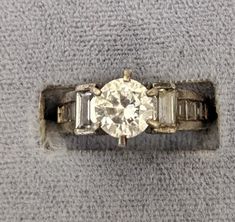 an old diamond ring sitting on top of a towel