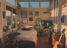 a bedroom with lots of windows and plants in it