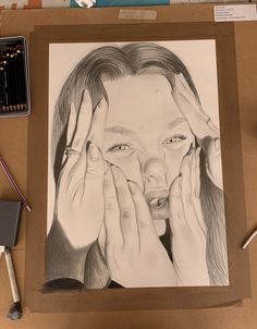 a pencil drawing of a woman holding her hands up to her face with both hands