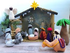 crocheted nativity scene with figurines in the foreground and on the right