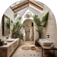 a bathroom with two sinks and plants in the shower area, along with an oval mirror