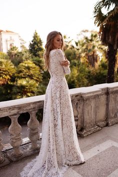 a woman in a white dress standing on a balcony