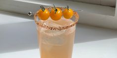 three oranges are placed on the top of a drink