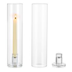 a tall glass candle holder with a lit candle in the middle and a smaller one next to it