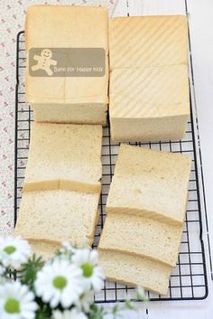 four slices of bread sitting on top of a cooling rack next to flowers and a vase