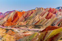 the colorful mountains are painted with different colors and shapes, as well as blue sky