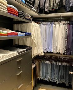 the closet is full of folded shirts and other items in it, including an open file cabinet