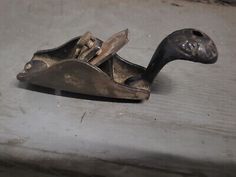 an old metal object sitting on top of a wooden table next to a window sill