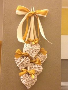 a heart shaped decoration hanging on the wall next to a doorway with yellow ribbon and bow