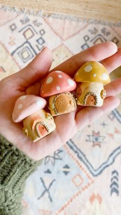 a person is holding some tiny mushrooms in their hand and they are painted with different colors