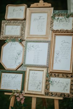 wedding seating cards on easel with flowers and greenery