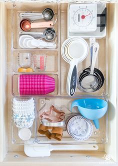 an organized drawer filled with utensils and other kitchen items, including measuring spoons