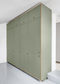 an empty room with several green lockers on the wall