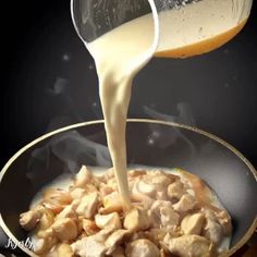 someone pouring milk into a pan filled with food