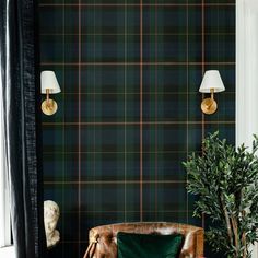 a living room with green plaid wallpaper and leather chair next to a potted plant