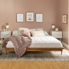 a bedroom with pink walls and white furniture