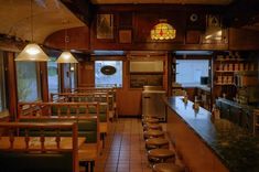 the inside of a restaurant with many tables and stools in front of it,