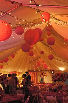 the inside of a marquee decorated with paper lanterns