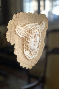 a sculpture of a woman's head on display in a glass case