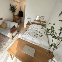 a living room with a couch, coffee table and laptop computer on it's desk