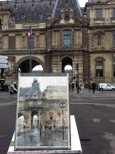 an easel sitting in front of a large building