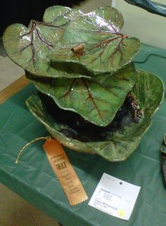 a large leafy bowl sitting on top of a green table