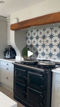 a stove top oven sitting inside of a kitchen next to white cabinets and counter tops