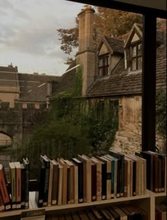 there is a bookshelf with many books on it in front of a window