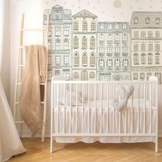 a baby's room with a white crib and wallpaper